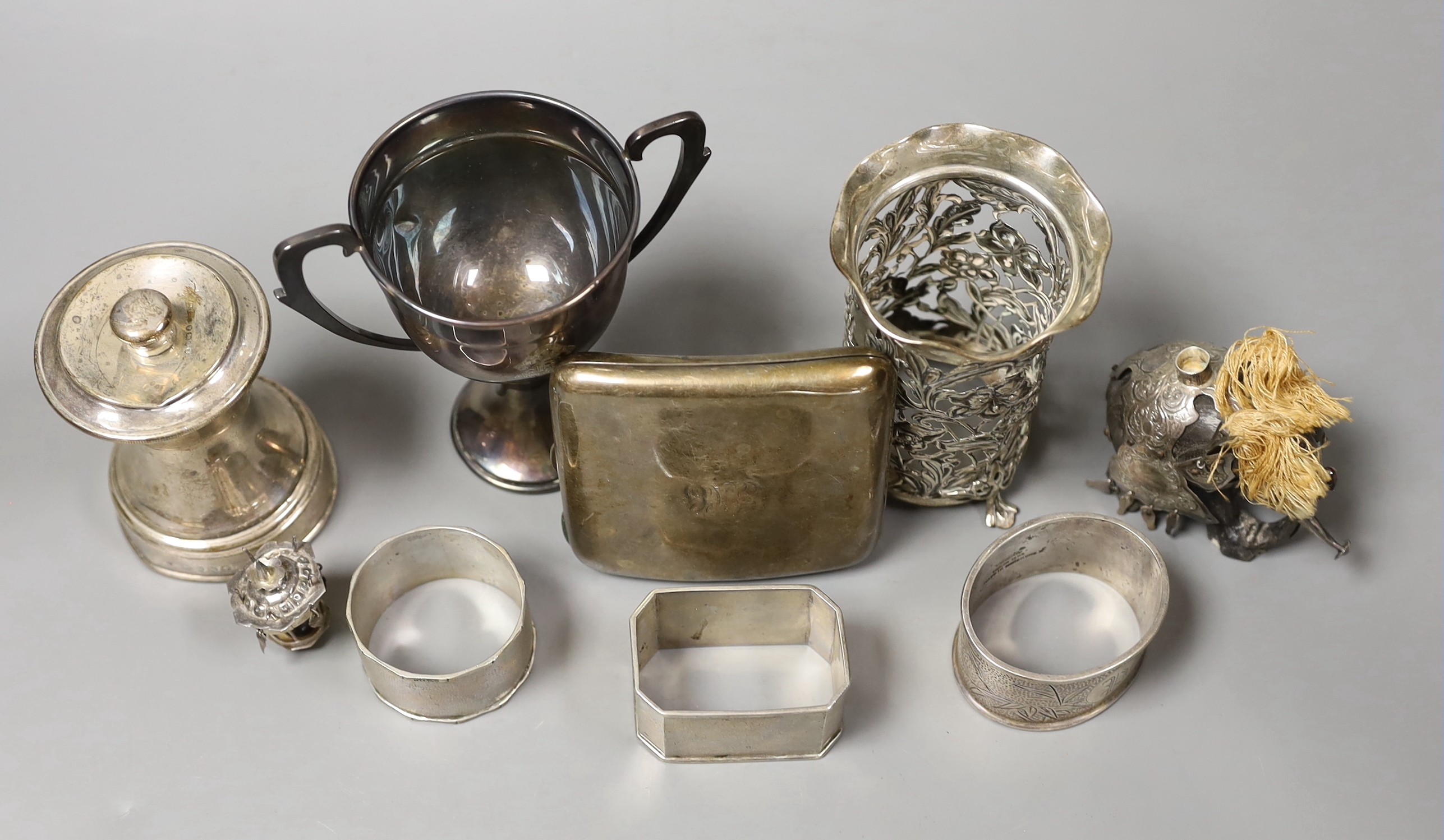 Sundry small silver including a late Victorian silver mounted pepper grinder, a paired silver vase, two handle trophy cup and a cigarette case, together with a white metal mounted miniature elephant with howdah and three